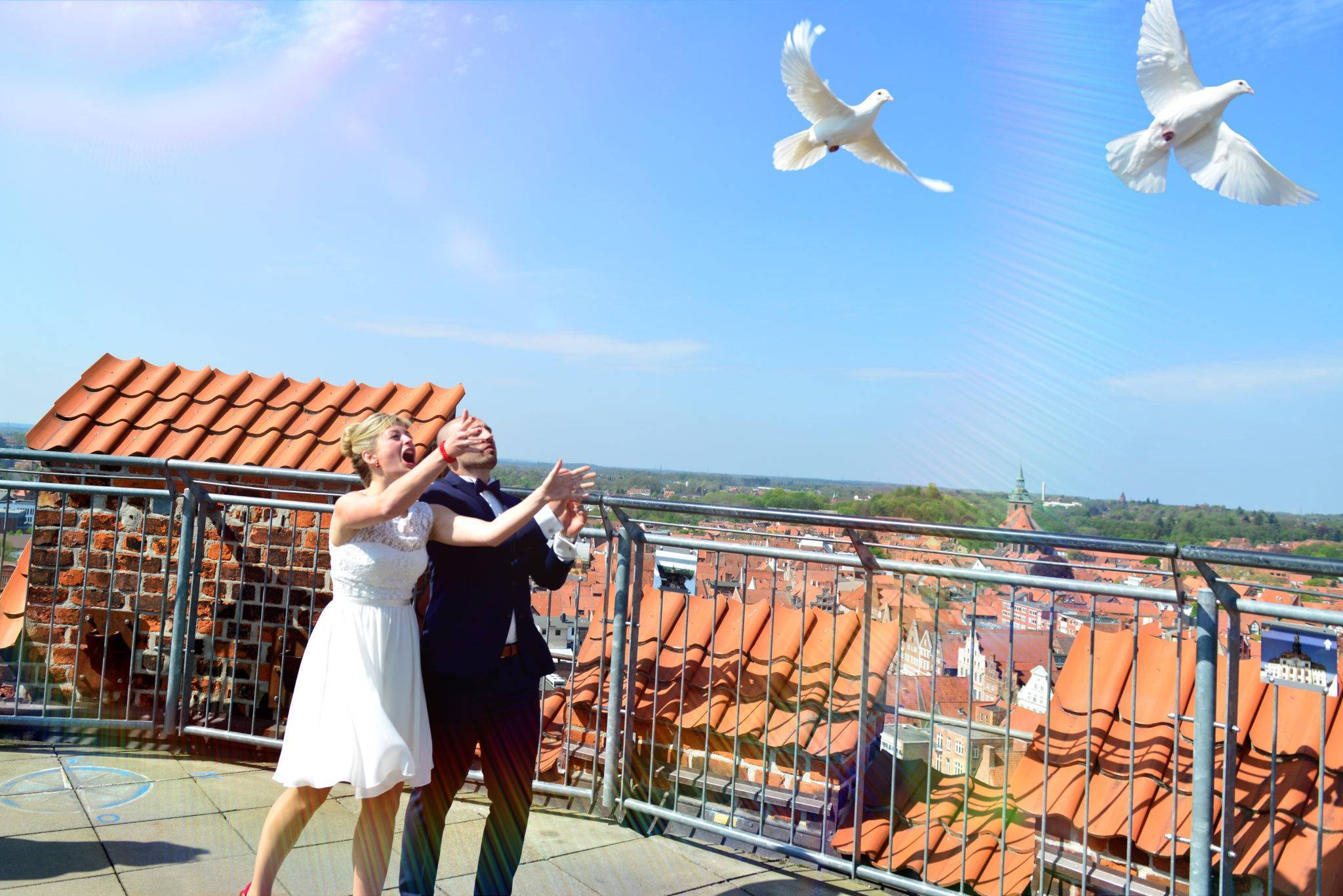 Hochzeitsfotografie auf dem Wasserturm mit Brautpaar und weißen Tauben - über den Dächern Lüneburgs