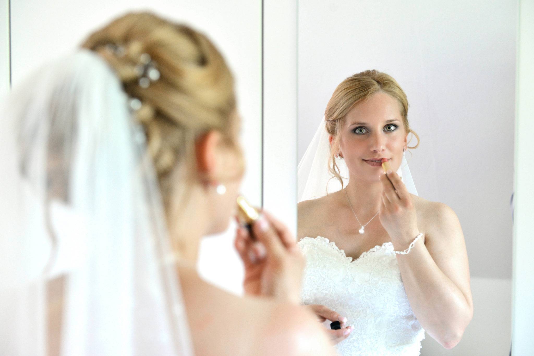 Hochzeitsfotografie Vorbereitung - Braut vor dem Spiegel im Brautkleid