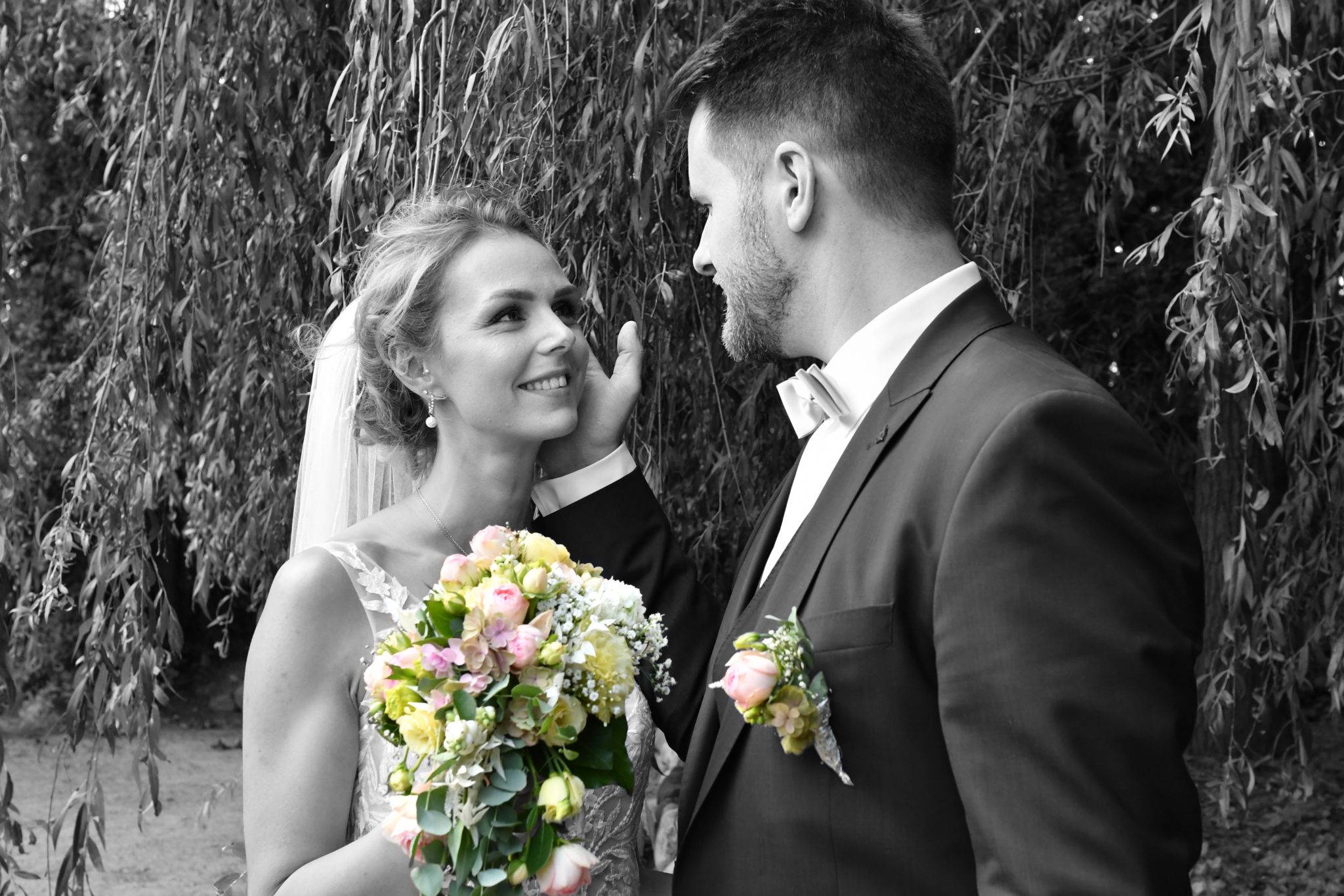 Brautpaarshooting in schwarzweiss mit schönem Brautstrauss in Farbe