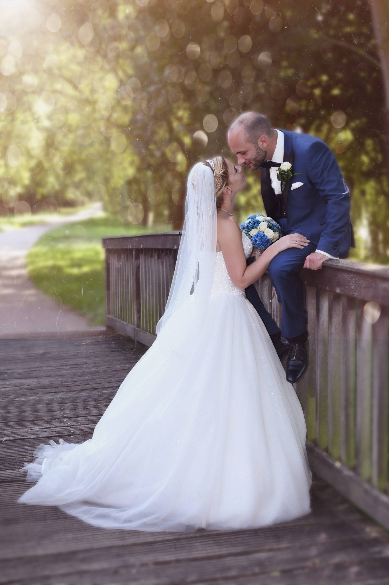 Brautpaar Fotoshooting auf einer Holbrücke mit Kuss