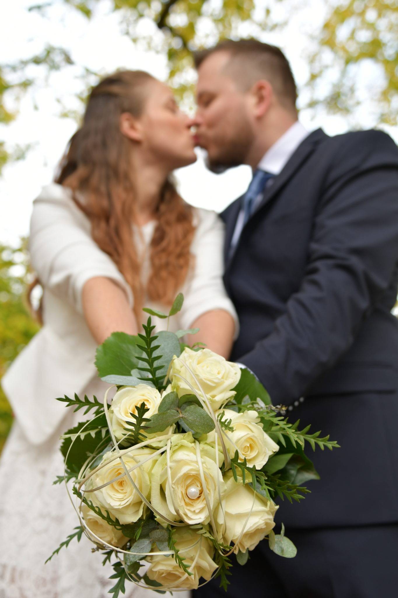 Brautpaarshooting mit Brautstrauss und Kuss