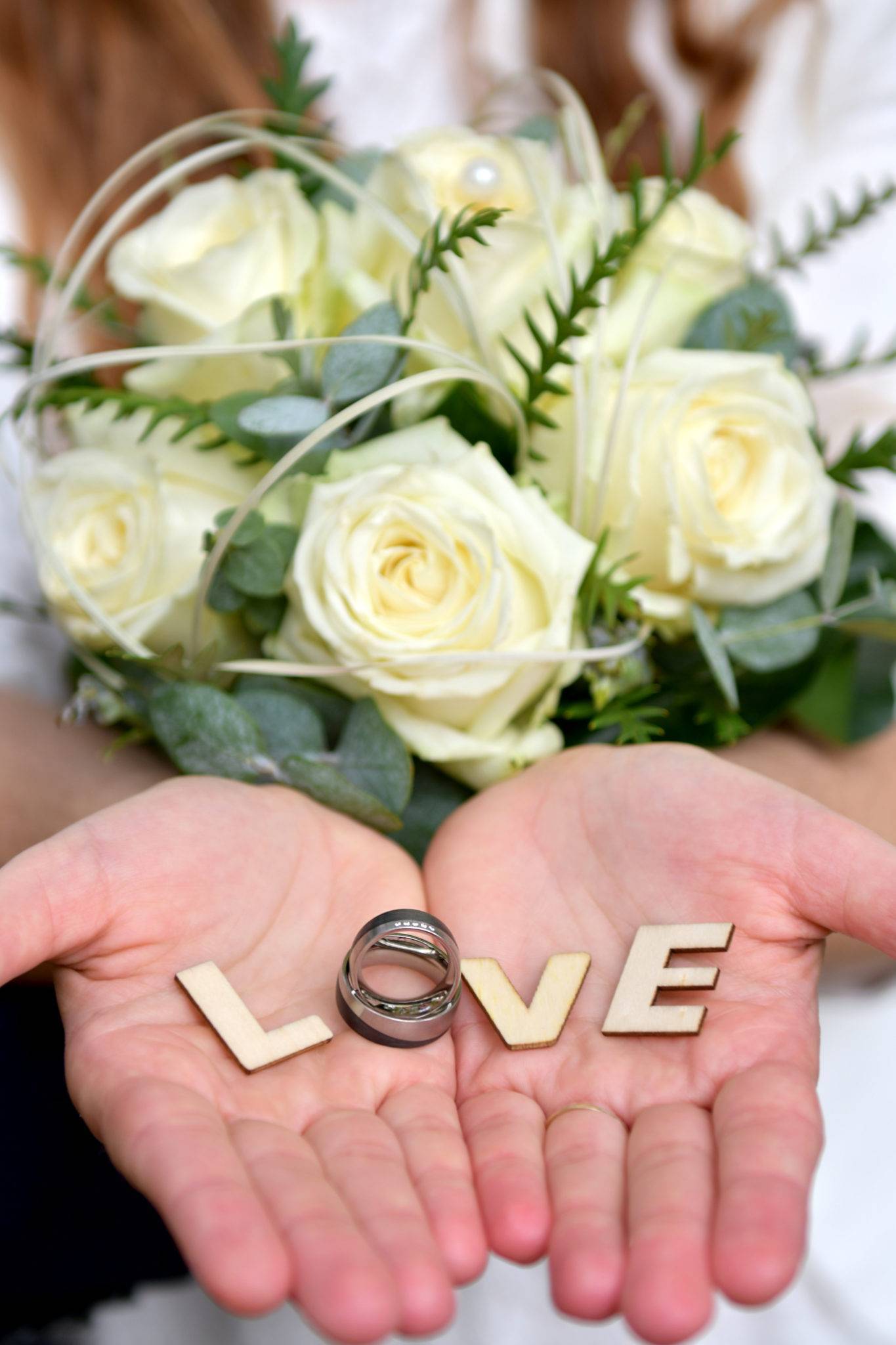 Hochzeitsfotoshooting mit Brautstrauss und Eheringen als LOVE in den Händen